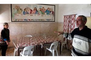 Salpi Magarian et son mari Michel Obejeh dans le réfectoire de leur maison de repos, au coeur du vieil Alep bombardé par le gouvernement. Au mur, une copie de la "Cène" de Leonard de Vinci, représentant Jésus lors de son dernier repas avec ses disciples.