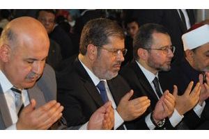  Mohamed Morsi, au centre, en prière pendant le ramadan en août 2012. 