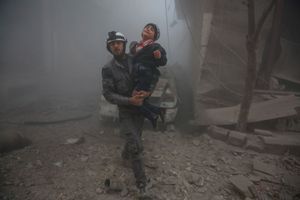 Un secouriste porte un enfant au milieu des ruines à Damas.