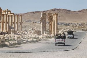 Des véhicules de l'armée syrienne près de l'arc de triomphe de la cité de Palmyre en Syrie