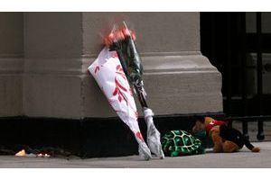  Devant l'appartement du drame, des anonymes ont déposé des fleurs et des peluches pour honorer la mémoire des défunts. 
