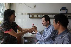  Zhang Tingzhen entouré de ses parents, dans sa chambre d'hôpital.