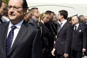 Manuel Valls, derrière François Hollande, fait face au policier qui a refusé de lui serrer la main.