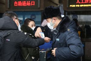 Des personnes se font contrôler leurs températures dans une station à Pékin, le 2 février 2020