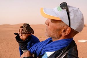 Un chercheur de météorite examine une pierre ramassée près de Zagora, au Maroc.