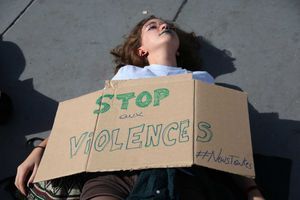 Place de la République à Paris, une femme manifeste avec une pancarte "Stop aux Violences".