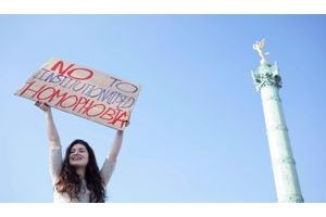 Le 21 avril, place de la Bastille, une jeune femme brandit une pancarte contre l'homophobie. 