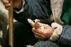 Une productrice de foie gras des Landes tient fermement une oie sur le point d'être gavée. 