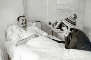 Claude Brasseur sur son lit d'hôpital, au lendemain de son accident de bobsleigh en janvier 1963, en compagnie de son épouse de l'époque Peggy. 