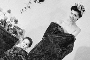 Luce Auger pose avec son fils dissimulé dans les plis de son manteau de Miss, fin janvier 1961.