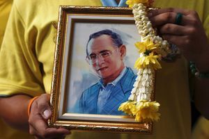 Un partisan des Chemises jaunes, mouvement aux couleurs du roi de Thaïlande, tient le portrait de Bhumibol lors d'une manifestation en l'honneur de son anniversaire, le 5 décembre 2014 à Bangkok.