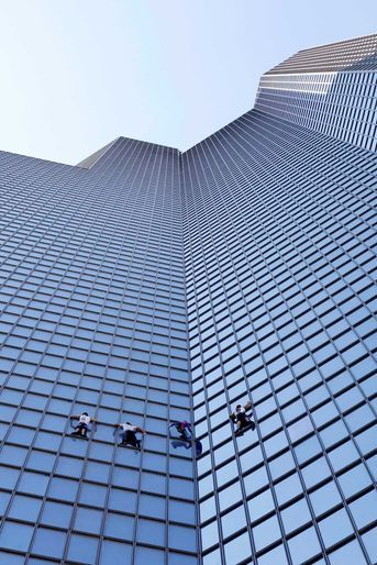 Alain Robert a escaladé la tour Total Coupole de la Défense, haute de 187 mètres, avec trois autres grimpeurs, sans le moindre équipement de sécurité.