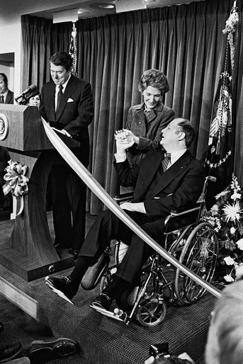 James Brady recevant un hommage appuyé du président Reagan et de son épouse Nancy, en novembre 1981, lors de sa première visite à la Maison Blanche après l&#039;attentat. Brady ne retrouvera jamais l&#039;usage de ses jambes.