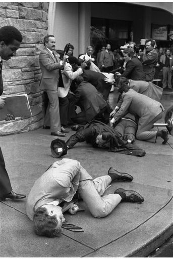 « Un des membres des services de protection qui s&#039;était interposé pour protéger Reagan, a été atteint au ventre et s&#039;est effondré en pivotant sur lui-même (1er plan). Les six balles du tireur étaient destinées au Président. Dans la panique et la confusion, ces trois hommes grièvement blessés l&#039;ont sauvé en lui faisant un rempart de leurs corps. » - Paris Match n°1663, 10 avril 1981.