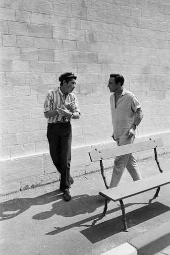 Rochefort (Charente-Maritime), France, juin 1966 : tournage du film "Les DEMOISELLES DE ROCHEFORT", de Jacques Demy : le réalisateur (avec casquette) s'entretenant avec Gene KELLY en marchant dans une rue de la ville.