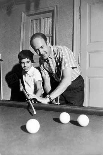 Valéry Giscard d'Estaing joue aux billard avec son fils Henri, 10 ans, dans la maison familiale de Chanonat, dans le Puy-de-Dôme, en août 1967.