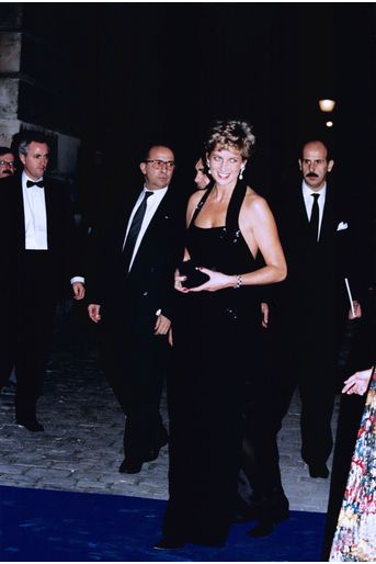 « Diana, à son arrivée au château, porte une robe de crêpe noir de Bruce Oldfield, qui est l&#039;un de ses couturiers favoris. Avec son décolleté plongeant, la robe est bordée de paillettes, et une longue fente laisse entrevoir les jambes de la princesse. » - Paris Match n°2376, 8 décembre 1994