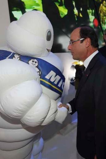 François Hollande serrant la main du bonhomme Michelin.