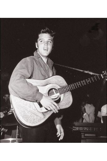 Surnommé "Pelvis" par ses détracteurs qui lui reprochent l'obscénité de ses déhanchements, Elvis devient "The King", après un passage au Ed Sullivan Show, où il apparait les cheveux gominés en noir. Photo prise dans les coulisses en 1956.