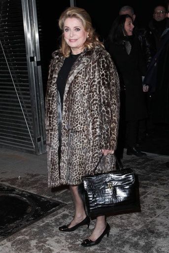 Le manteau léopard : Catherine Deneuve assiste au défilé Etam automne-hiver 2014-2015 à Paris, le 25 février 2014