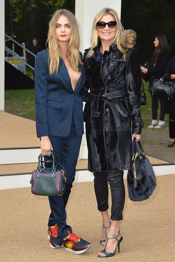 Les mannequins Cara Delevingne et Kate Moss assistent au défilé printemps-été 2015 Burberry Prorsum dans des tenues de la griffe, lors de la Gas...