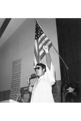 ﻿Le révérend Jim Jones lève le poing, lors d'un prêche. Cette photo, sans date ni lieu, fait partie de l'album retrouvé à Jonestown, après le suicide collectif.