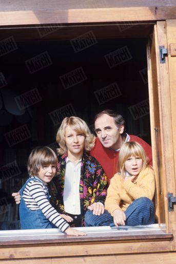 Charles Aznavour son épouse Ulla et leurs enfants Misha, âgé de 5 ans et Katia, âgée de 8 ans, à la fenêtre de leur maison en Suisse, en novembre 1977.