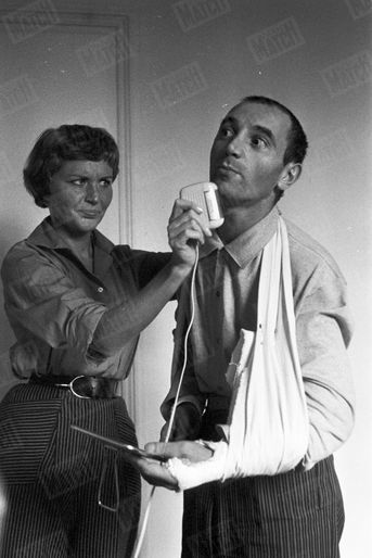 Pour sa toute première photo dans Match, Charles Aznavour, les deux bras plâtrés après un accident de voiture, se fait raser par son épouse Evelyne Plessis, le 4 octobre 1956.