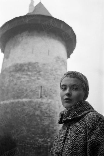 Pour sa première visite en France, Jean Seberg, qui interprète le rôle de Jeanne d'Arc dans le film "Sainte Jeanne" d'Otto Preminger, a voulu visiter les lieux où l'héroïne a vécu. De passage à Rouen, elle a refait le trajet entre la cathédrale et le bûcher. Ici, devant la tour où l'héroïne fut emprisonnée à Rouen, le 24 décembre 1956.