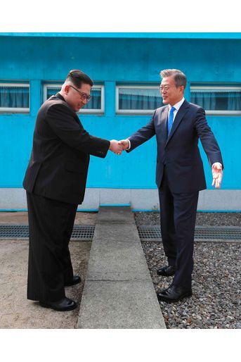 Poignée de main entre Kim Jong-un et Moon Jae-in au dessus de la ligne de démarcation séparant les deux Corées.