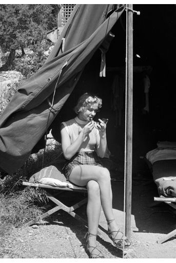 Côte d'Azur, 1955 : séance de maquillage à l'abri du soleil sous la tente.