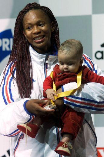 Aux championnats du monde 2001, Laura Flessel pose avec sa médaille d&#039;argent et sa fille Leïlou.