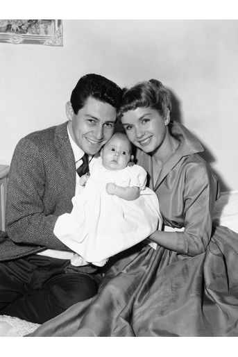  Eddie Fisher et Debbie Reynolds portent la petite Carrie dans leurs bras.
