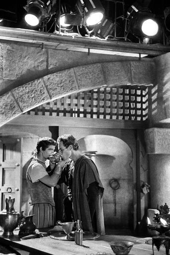 Bras croisés, yeux dans les yeux, Stephen Boyd et Charlton Heston partagent une coupe de vin dans une scène mémorable.