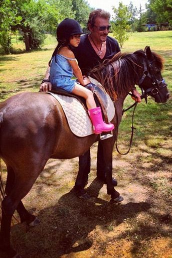 Johnny Hallyday guide sa petite fille sur un cheval