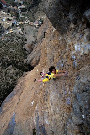 En Espagne, dans le massif de Los Riglos de Mallos, Catherine Destivelle, suspendue par les mains, escaladant le pic du Pison.