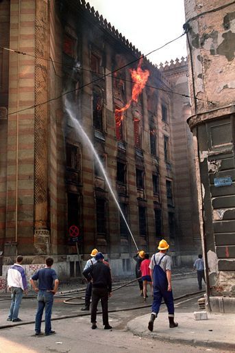 Des pompiers éteignent le feu de la bibliothèque de Sarajevo, le 26 août 1992.