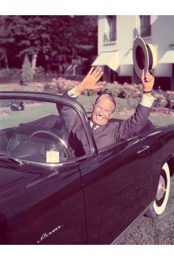 Au Salon d’octobre 1956, Maurice Chevalier pose au volant d’un cabriolet Simca Aronde Océane, sur le pare-brise duquel on distingue la vignette créée cette année-là.