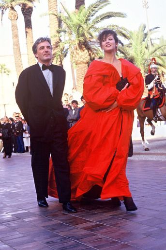 Sophie Marceau enveloppée dans son manteau rouge vif, avec son compagnon, le réalisateur polonais Andrzej Zulawski, au Festival de Cannes en 1987. 