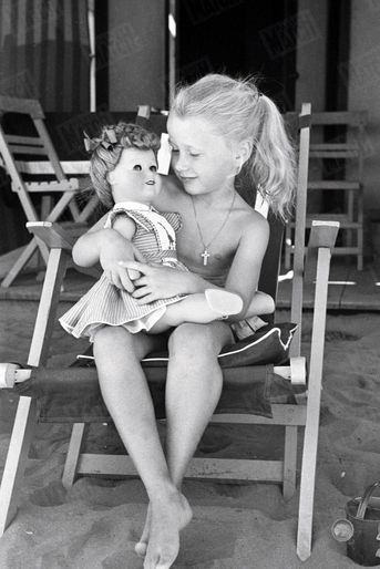 Avec sa poupée Simone sur la plage du Lido lors de la 12e Mostra de Venise, en 1952. « Jeux interdits », le film qui la révèle, reçoit le Lion d’or, récompense suprême.