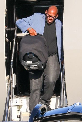 Rihanna, son compagnon A$AP Rocky et leur bébé, porté soigneusement par un garde du corps, descendent de leur jet privé à leur retour à Los Angeles, le 14 août 2022.