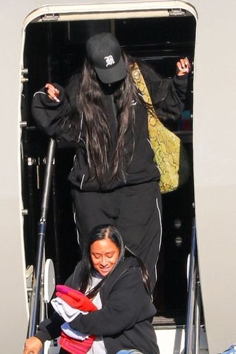 Rihanna, son compagnon A$AP Rocky et leur bébé, porté soigneusement par un garde du corps, descendent de leur jet privé à leur retour à Los Angeles, le 14 août 2022.