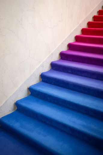 L'escalier qui mène au bureau du président, au premier étage, offre un dégradé de bleu et rouge.