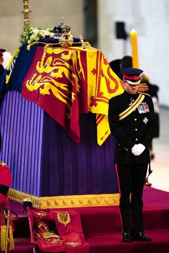 Le prince Harry, dans son uniforme militaire, dos au cercueil de la reine.