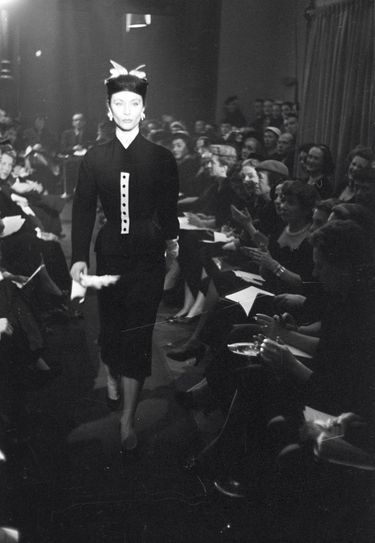 Défilé pour Hubert de Givenchy. Bettina n’est pas seulement le mannequin vedette du couturier, elle l’aide à lancer sa première collection, en 1952.