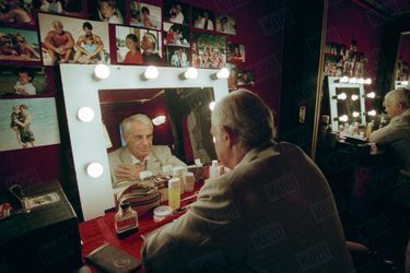 Octobre 1996. Belmondo face à lui-même, dans sa loge du théâtre des Variétés dont il est le propriétaire depuis cinq ans et où il joue « La puce à l’oreille », de Feydeau, mis en scène par Bernard Murat.