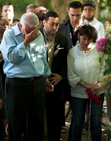 Les parents d’Amy Winehouse, Mitch et Janis, pleurent la mort de leur fille, devant les fleurs déposées par ses fans, à Camden Square, le 25 juillet 2011.