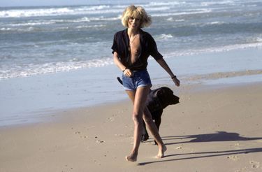 1982. Sauvageonne sur la plage, avec le labrador Manu, qu’elle partageait avec Alain Delon.