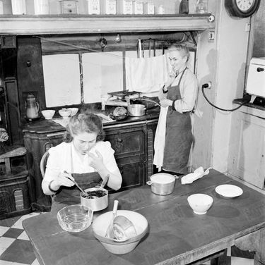 « Sous l'œil de la cuisinière, elle goûte la crème au chocolat qu'elle vient de confectionner. » - Paris Match n°105, 24 mars 1951