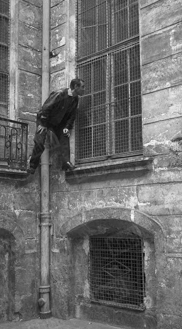 Charles Aznavour dans le quartier de son enfance, perché sur la fenêtre de son école.